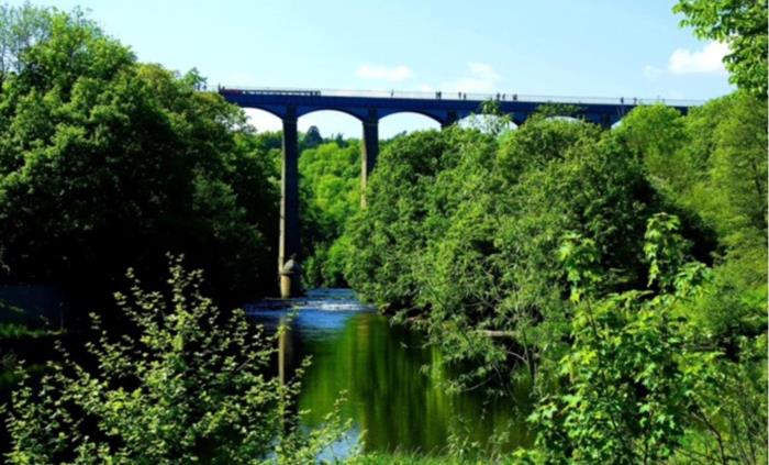 A view of the Poncysyllte Aqueduct, canal boats and people crossing it.